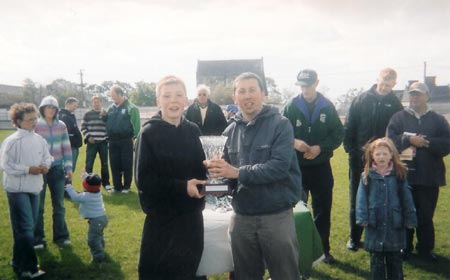 The Setanta captain, Richard Kee being presented with the Seamus Grimes memorial trophy.