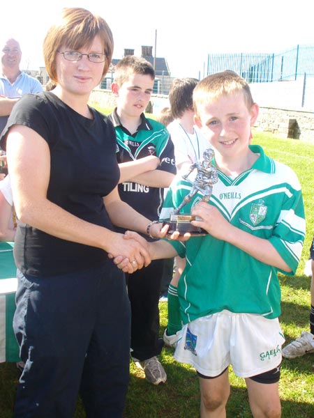 Caroline Ryan presenting the player of the tournament award to Kieran Corrigan from Lisbellaw.