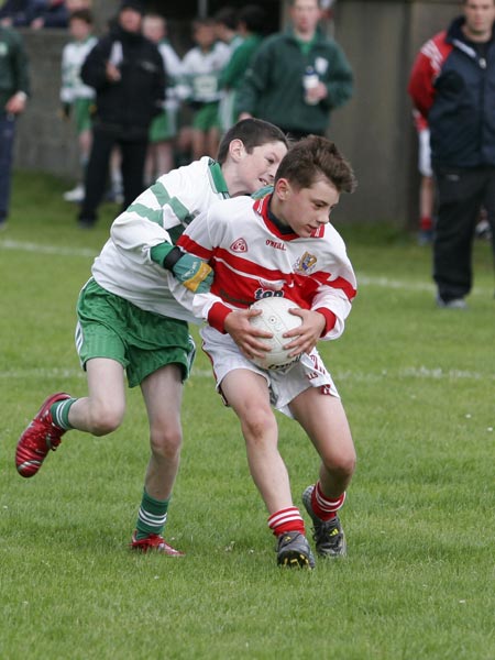 Eoin Scally of Dungloe holds off the challenge of Johnny Gethins.