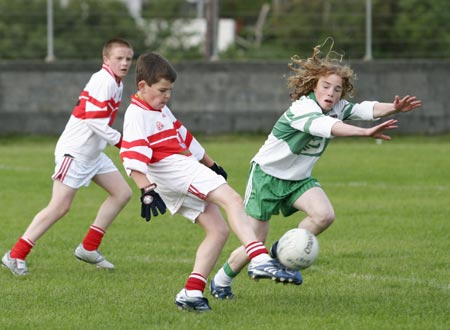 Matthew Ward of Dungloe clears his lines with Pauric Patton of Aodh Ruadh attempting the block.