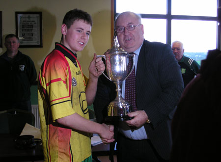 The winning Bakery Cup captain of 2007, Ronan McGurrin, receives the trophy from the winning Bakery Cup captain of 1957, Padraig McGarrigle.