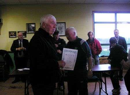 Alan Kane receives a certificate commemorating his participation in the Bakery Cup from the Chairman of Bord na nÓg, Jim Kane.