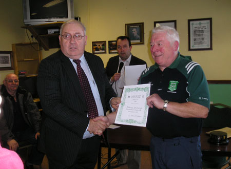Padraig McGarrigle receives a certificate commemorating his participation in the Bakery Cup from the Chairman of Bord na nÓg, Jim Kane.