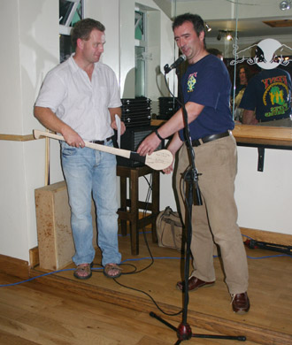 John Rooney, who organised the evening, presenting a hurl signed by both teams to Dennis.