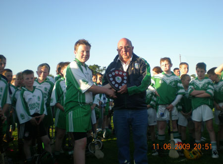 Davy Bannon, chairman of the Fermanagh Hurling Board, presents the under 12 Fermanagh shield to the winning captain Conor Kennedy.