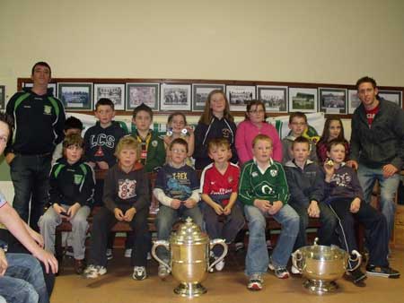 Under 10 squad with manager Michael Ayres and Michael Fennelly with Bob O'Keefe and National League trophies.