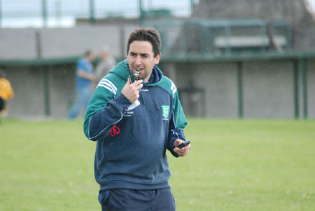 Referee, Barry Travers battles the elements.