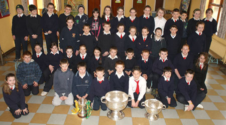 Senior clases from Holy Family National School, Ballyshannon pictured with the Sam Maguire, Tom Markham (All-Ireland minor football championship) and McKenna cups when they visited their school last Friday.