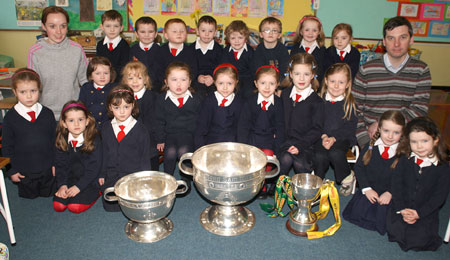 Junior Infants from Holy Family National School, Ballyshannon pictured with the Sam Maguire, Tom Markham (All-Ireland minor football championship) and McKenna cups when they visited their school last Friday.