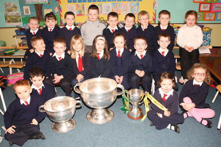 Senior Infants from Holy Family National School, Ballyshannon pictured with the Sam Maguire, Tom Markham (All-Ireland minor football championship) and McKenna cups when they visited their school last Friday.