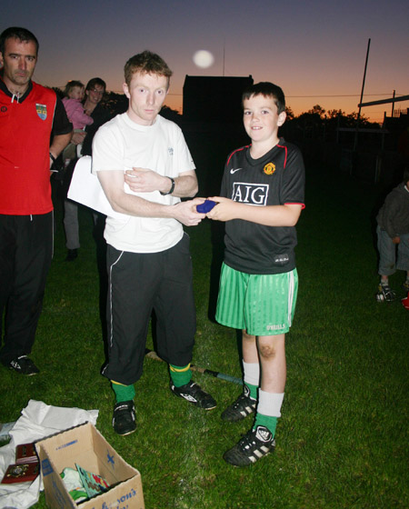 Peter Horan presenting Patrick Cassidy in medal for coming third in the under 10 skills competition.
