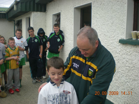 Eddie Lynch, under 8 manager, presenting Matthew McDonald, fourth in the under 8 section with his medal.