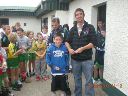 Michael Ayres, under 10 joint manager with Kevin McDermott in background, presenting Brian McHenry, sixth in the under 10 section with his medal.