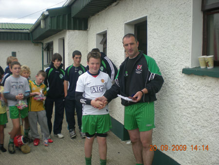 John Rooney, under 12 manager, presenting Conor Kennedy, fourth in the under 12 section with his medal.