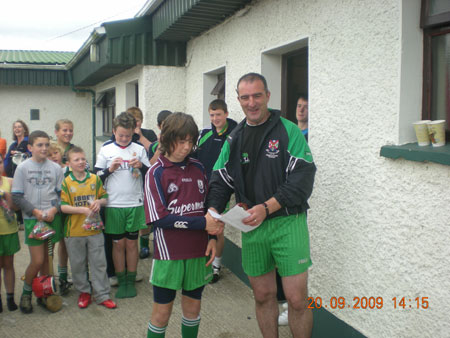 John Rooney, under 12 manager, presenting Oisín Rooney, first in the under 12 section with his medal.