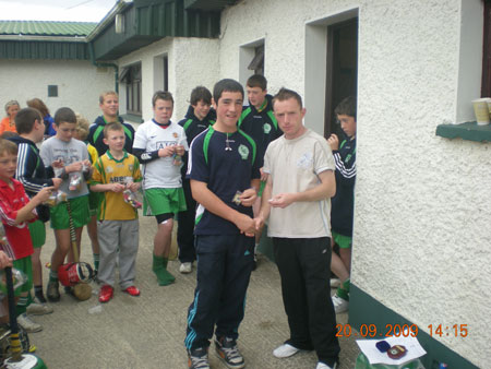 Peter Horan, under 14 manager, presenting Jamie McDonald, sixth in the under 14 section with his medal.