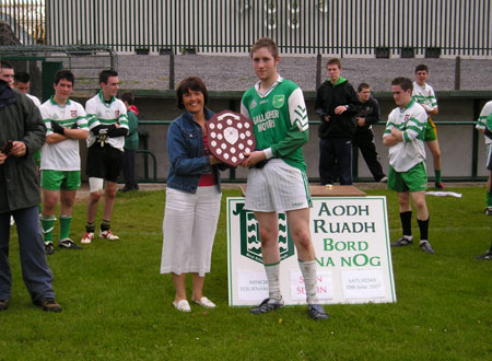 Sean Slevin's widow, Patricia, presents the Sean Slevin plaque to the victorious Bunninadden captain, Vincent Frizzell.