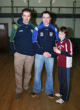 Alan Kerins, Galway senior hurling star, presents Oisin Rooney with his county under 12 hurling medal accompanied by mentor, John Rooney.