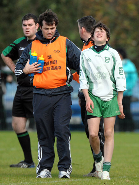 Aodh Ruadh manager Niall McCready helps Colm Kelly deal with the pain of injury and the thought of having to be substituted during Saturday's final.
