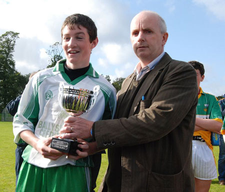 Johnny Gethins takes delivery of the under 14 championship trophy.