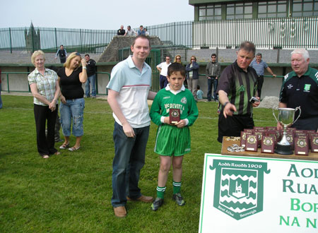 Gavin Rogers presents a plaque to the Erne Gaels Captain after the final of the Willie Rogers under 12 tournament in Ballyshannon last Saturday.